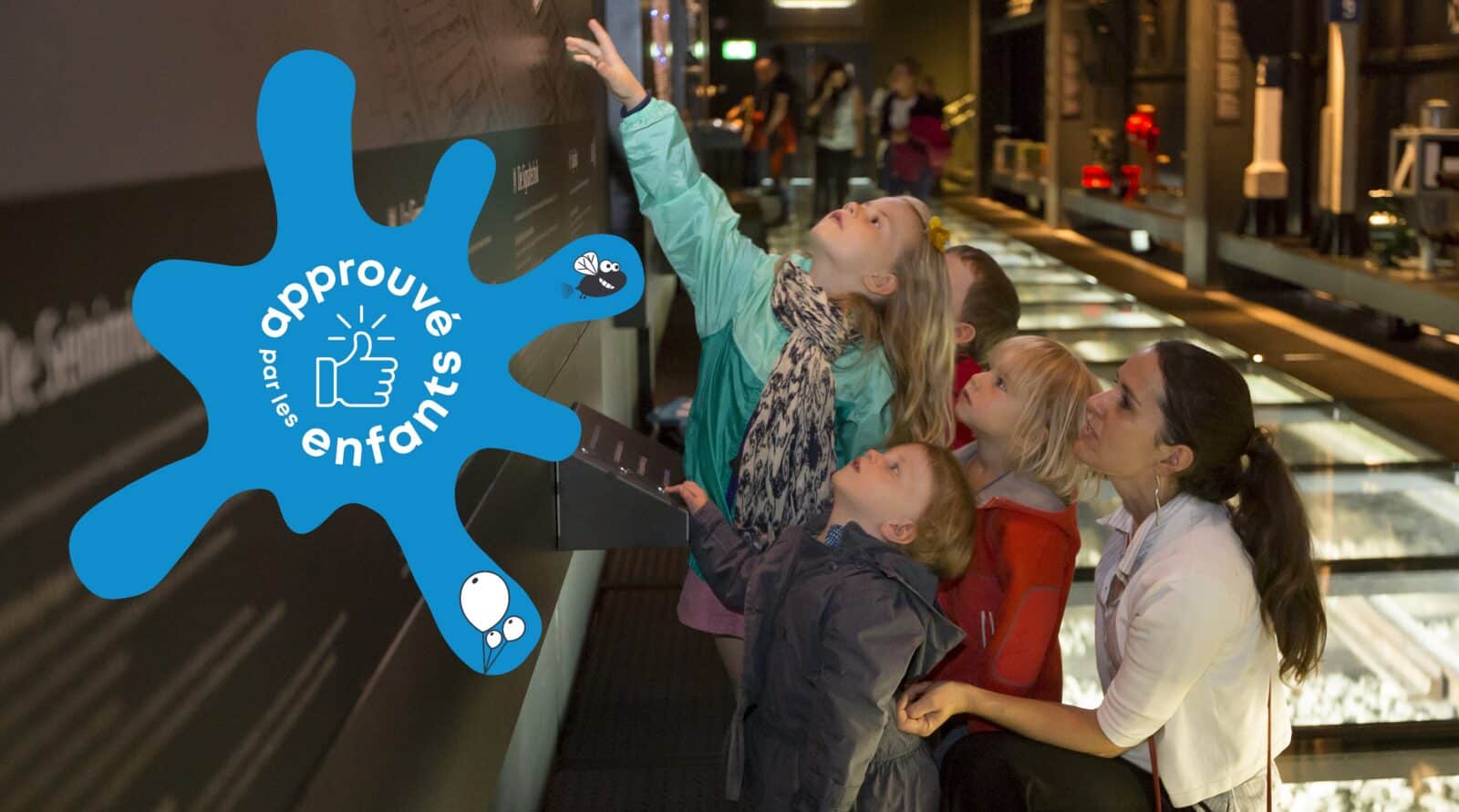 Famille explorant une exposition interactive avec un logo "approuvé par les enfants