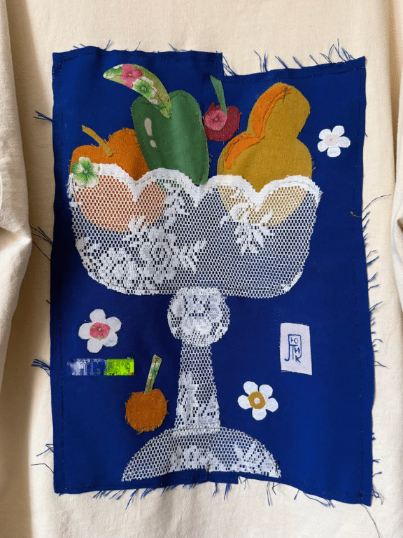Appelmoes en fruitstukken in een schaal, handgemaakt met stof en kant.