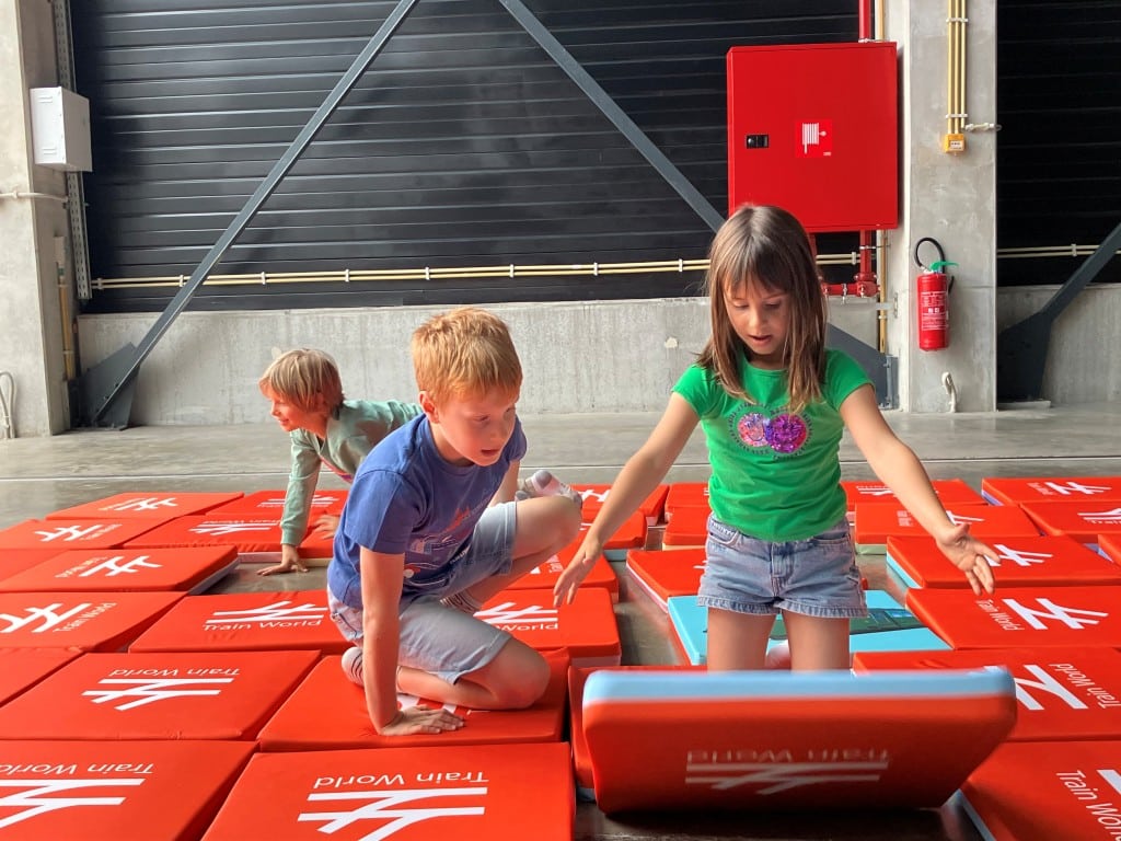 Kinderen spelen memory met Train World logo op rode matten